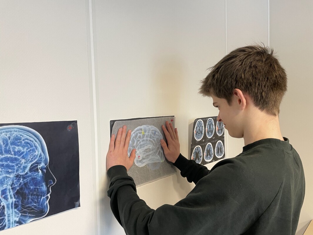 Aske studerer plakater, som giver lokalet en stemning af laboratorium Aske studerer plakater, som giver lokalet en stemning af laboratorium