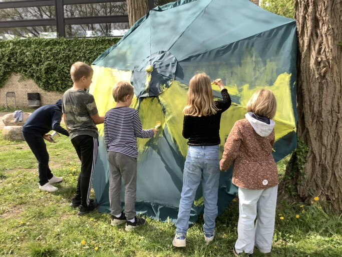 Eleverne maler den store parasol gul Eleverne maler den store parasol gul