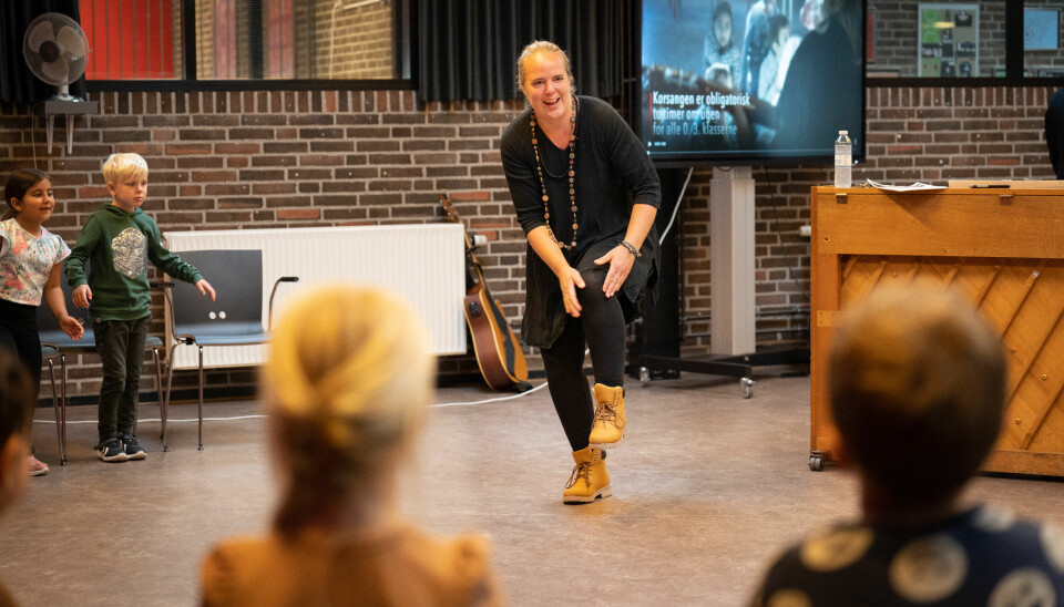 Signe Sørensen er korleder ved Herstedøster Kirke og hjælper eleverne med at 'sige godmorgen til knæene'. Hun har selv udviklet den pædagogik, der bruges i 'Alle kan synge'.