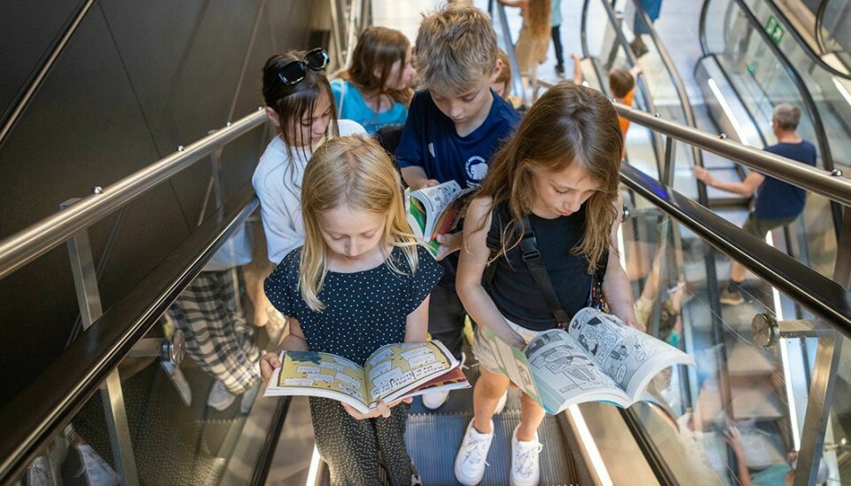 Eleverne vælger selv, hvilken bog de har lyst til at læse, når de tager på læseaktion i det offentlige rum. Her er 4.v på rulletrapperne i metroen.