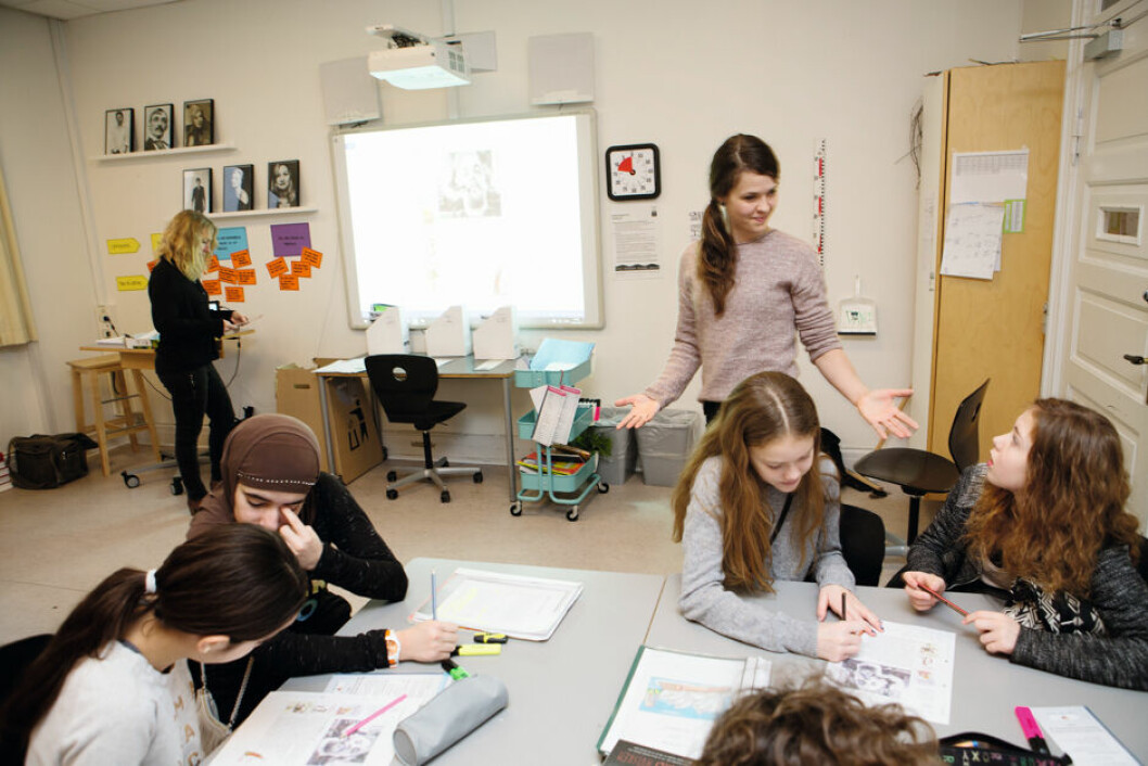 Iben May Dyresen taler med eleverne ved arbejdszonen skønlitteratur. I baggrunden observerer Tina Schiolborg klassens arbejde.