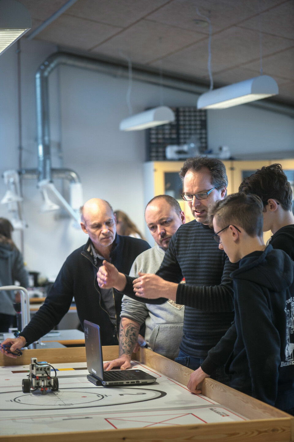 Christian Svenstrup vejleder eleverne Lukas og Patrick i, hvordan gyrosensoren i robotten virker, mens lærerne Bjarne Høg og Martin Gordon lytter med.